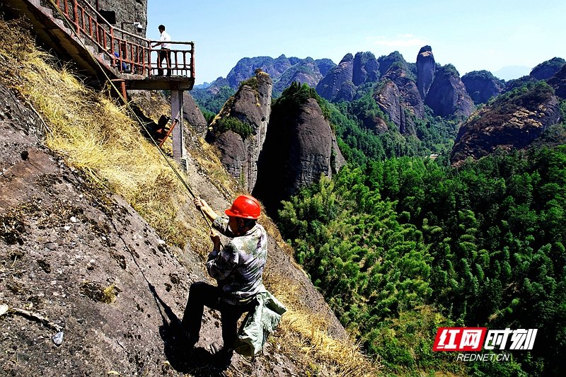 3.刘锋的日常工作是捡拾景区崖壁上的白色垃圾。.jpg
