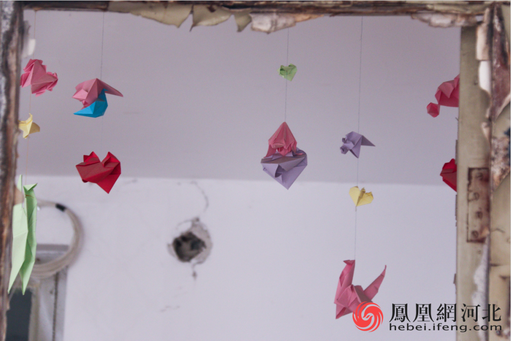 挂着装饰门框的千纸鹤、爱心。 李卓然/摄