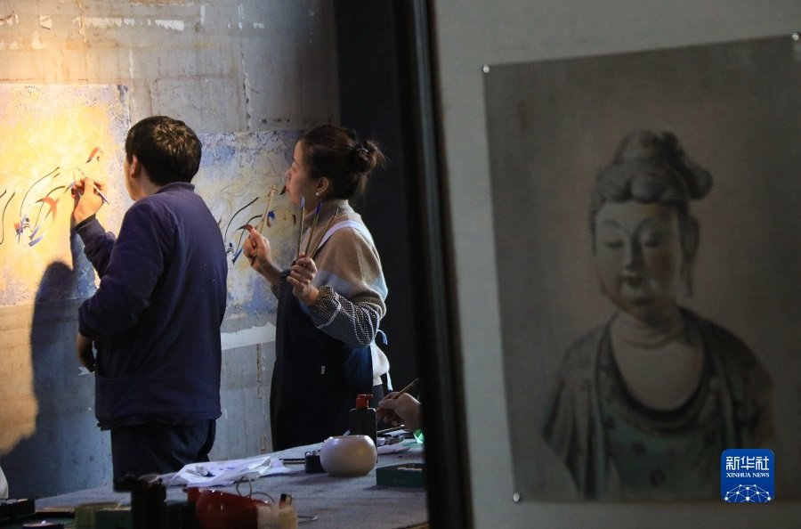 2月22日，在敦煌小镇鸣沙书院，艺术工作者张杰龙（左）指导学员临摹敦煌壁画。新华社发（张晓亮 摄）