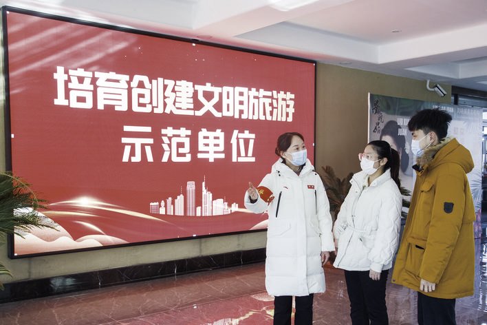 在净月潭国家森林公园游客服务中心内，文明旅游引导员正在为游客做引导服务。