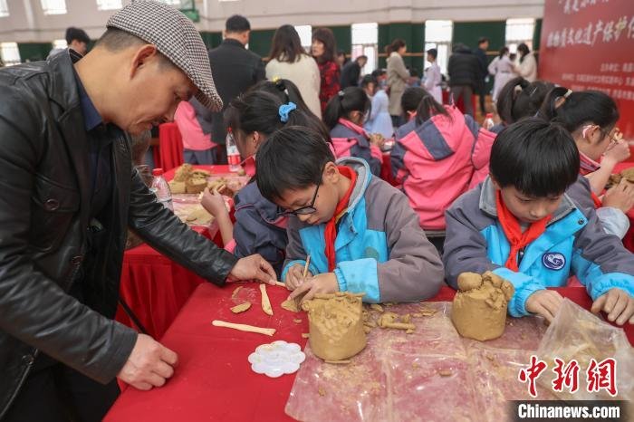 图为南昌市级非遗南昌泥塑的传承人在指导学生。　刘力鑫 摄