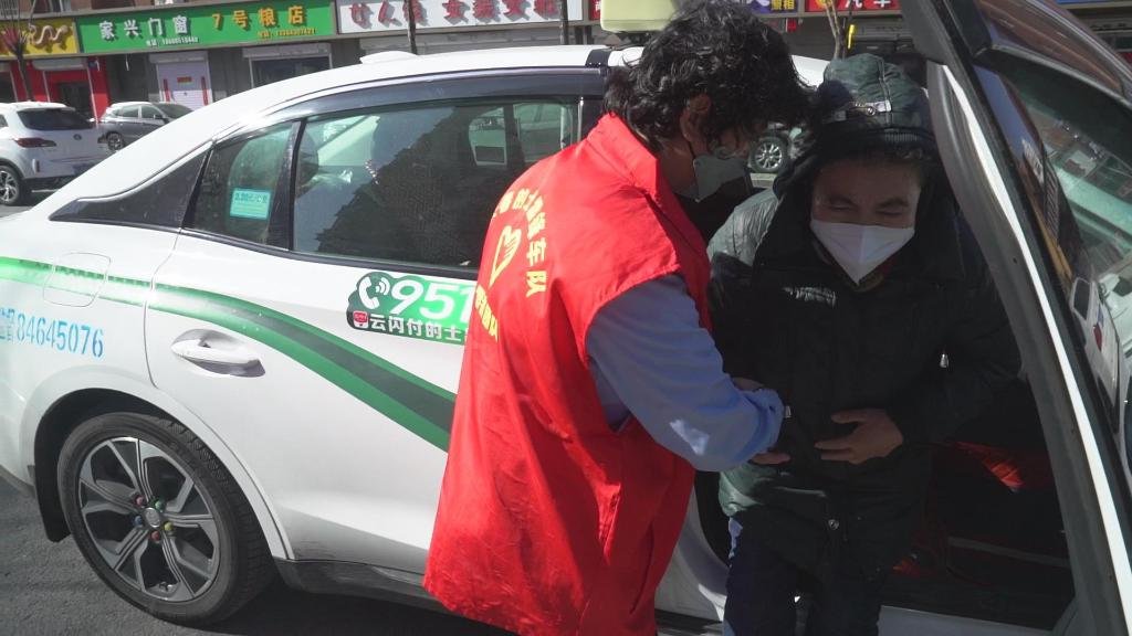 长春市雷锋车队司机杨玉华扶乘客下车。新华社记者周万鹏 摄