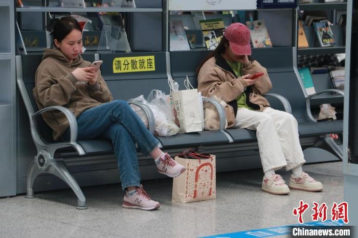 图为游客打包螺蛳粉，准备带上动车。　林馨 摄
