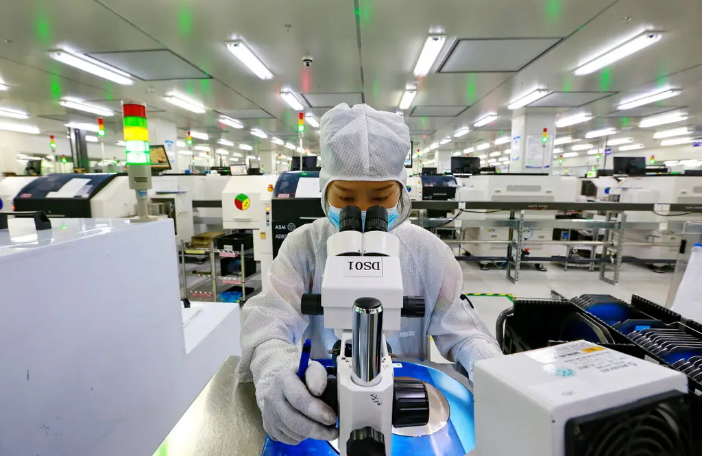 图/2022年5月，一名工人在中国遂宁的一家半导体制造商检查产品。图源：美联社