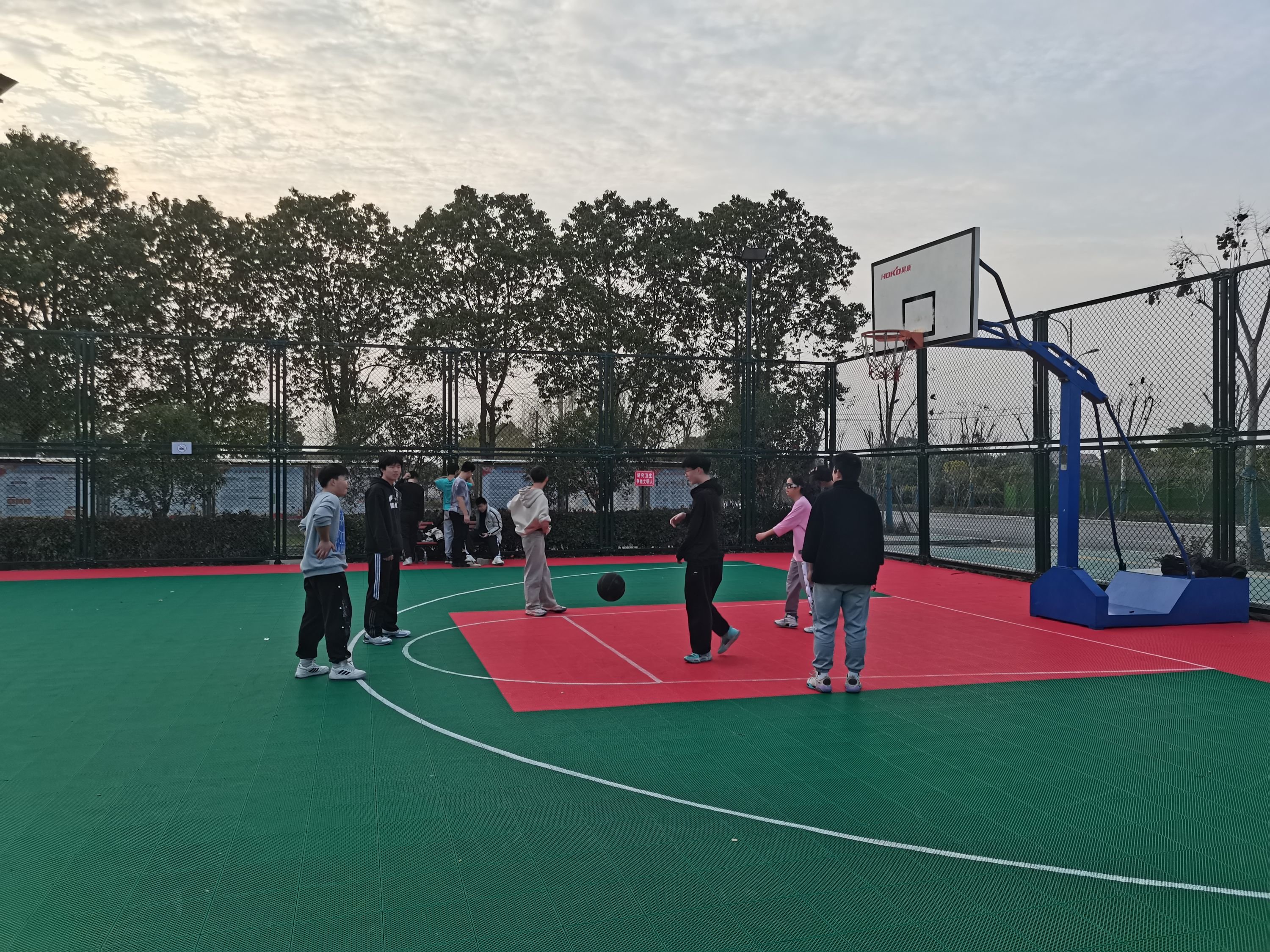 晚饭后，几名篮球爱好者在焕新的篮球场上打球。 朝前社区 供图