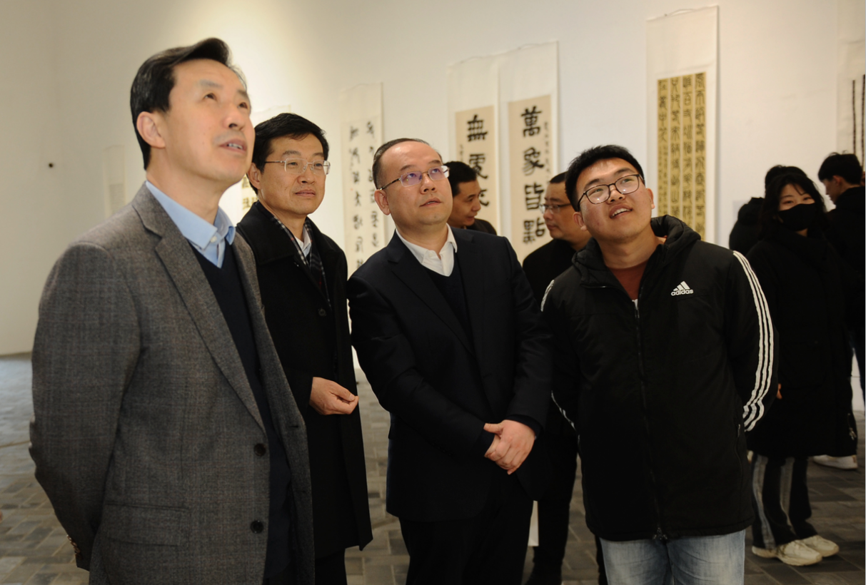 李征、张作昌、谢长伟等领导与青年作者一起观看展览（郭勇摄影）