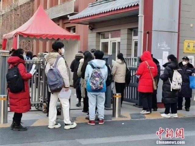 资料图：2023年国考北京一考点外，考生正在排队进入考场。刘欢 摄