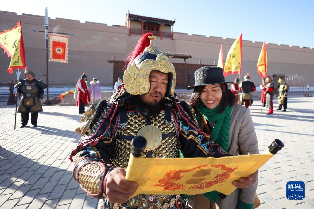 3月4日，游客在嘉峪关关城景区与工作人员互动交流。新华社记者 马希平 摄