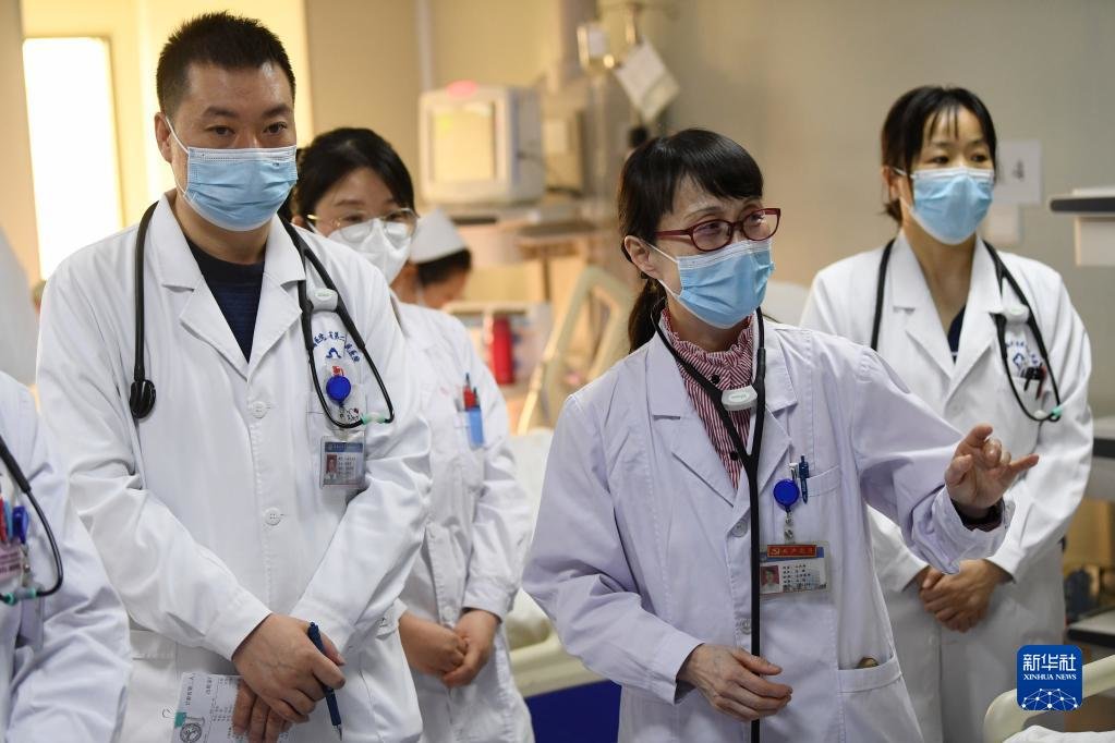 3月6日,马娜(右二)和同事在病房内查房。新华社记者 陈斌 摄