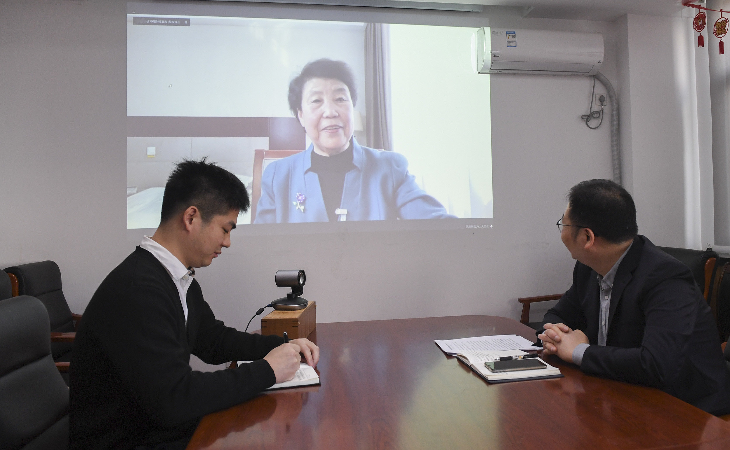 3月8日，农业农村部市场与信息化司监测统计处处长邓飞（右）及同事在农业农村部会议室与全国人大代表、山西省昔阳县大寨镇大寨村党总支书记郭凤莲视频连线。新华社记者 戴天放 摄