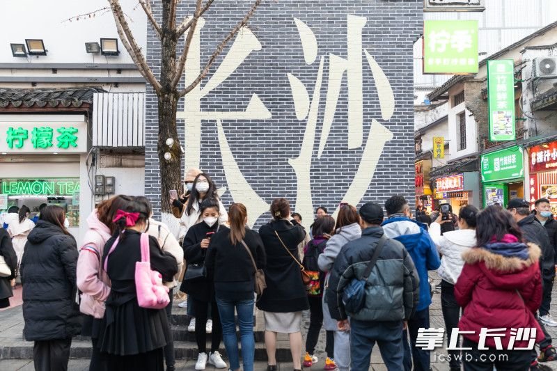 3月4日，长沙艳阳高照，太平老街热闹非凡。老街“长沙”文化墙前拍照打卡的人群摩肩接踵，街头巷尾烟火气十足。长沙晚报全媒体记者全媒体记者 董阳 摄