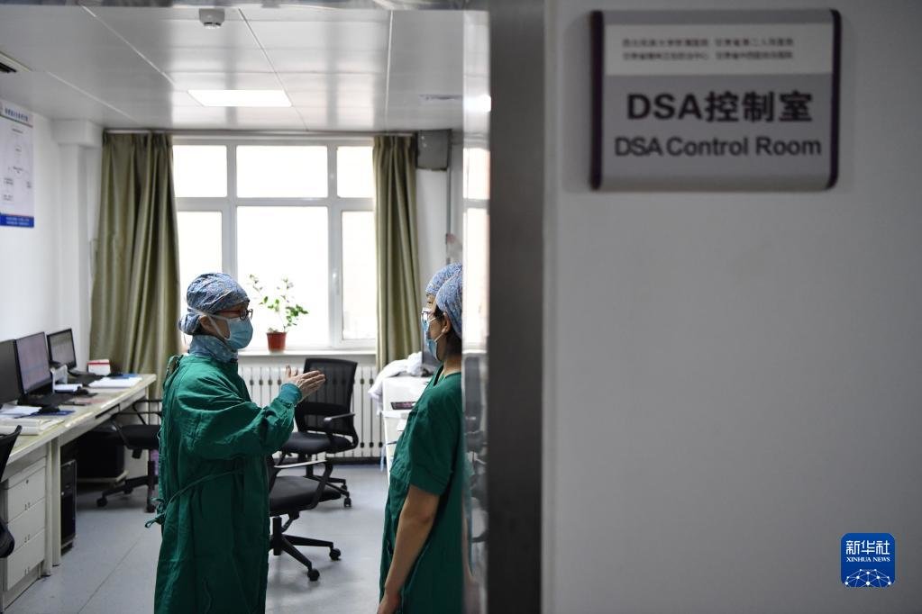 3月7日,马娜(左一)和同事交流患者病情。新华社记者 陈斌 摄