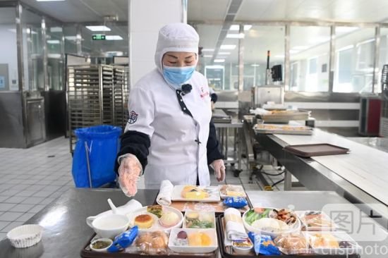 3月14日，记者探访位于兰州新区的甘肃东方航空食品有限公司，揭开航空餐食的“神秘面纱”。图为工作人员展示装配好的飞机餐。 中新社记者 九美旦增 摄