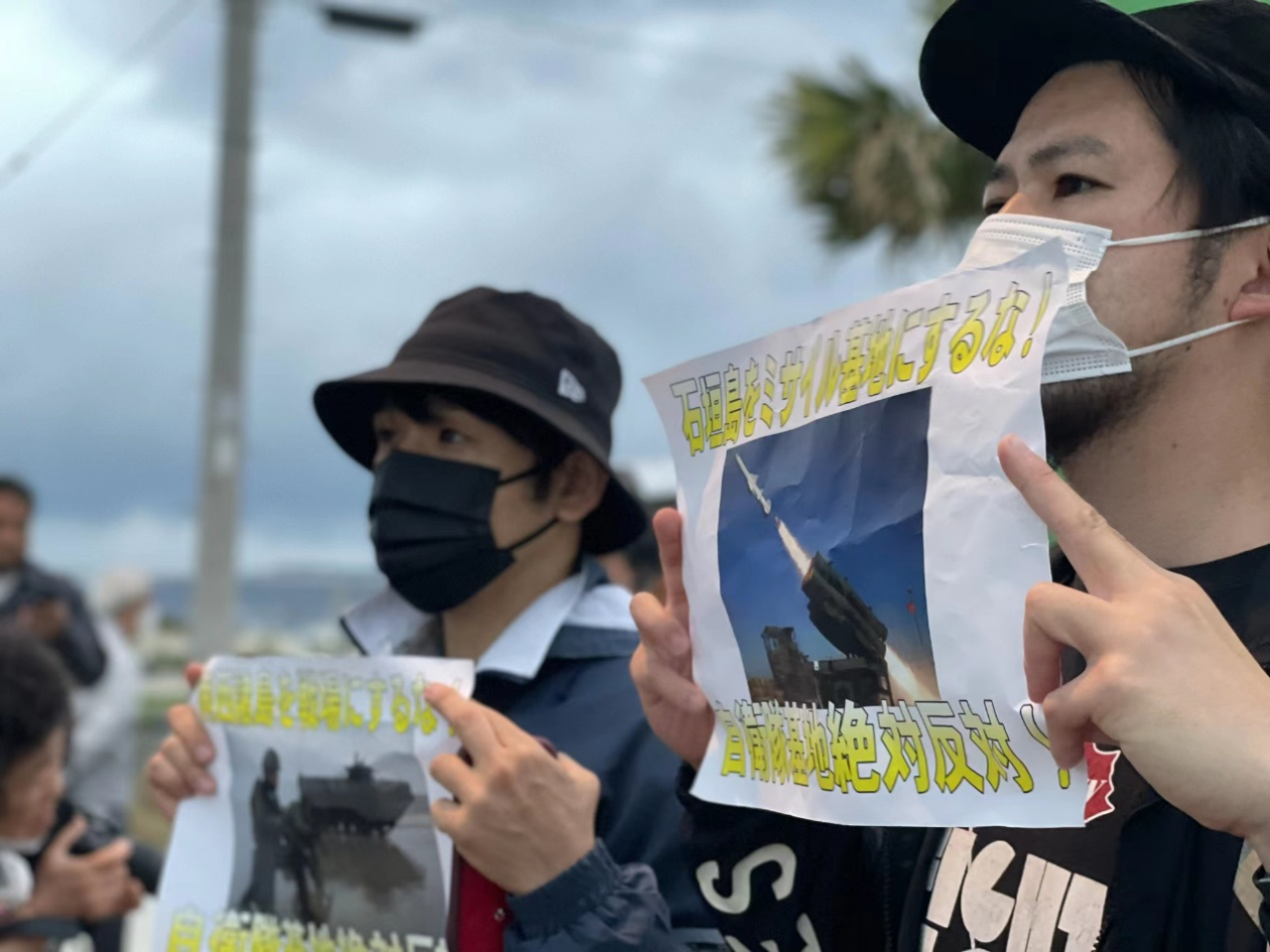 18日，日本民众拿着“反对将石垣岛变为导弹基地”的标语。图自社交媒体