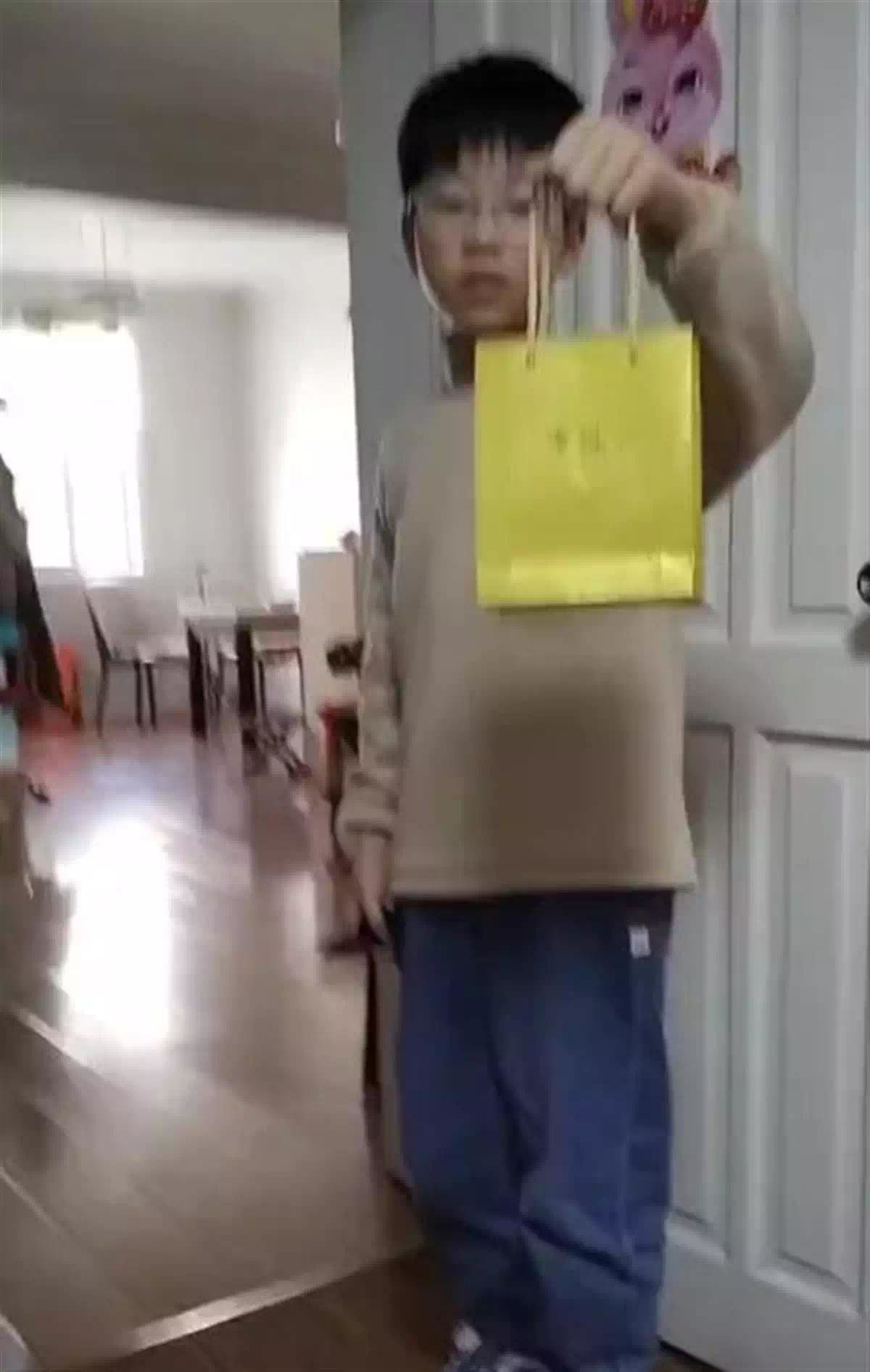 儿子向梁女士展示给她买的礼物（视频截图）