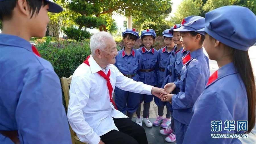 抗战老兵万更志（左二）给于都县长征源小学的学生讲述红色故事（2018年9月29日摄）。新华社记者 胡晨欢 摄