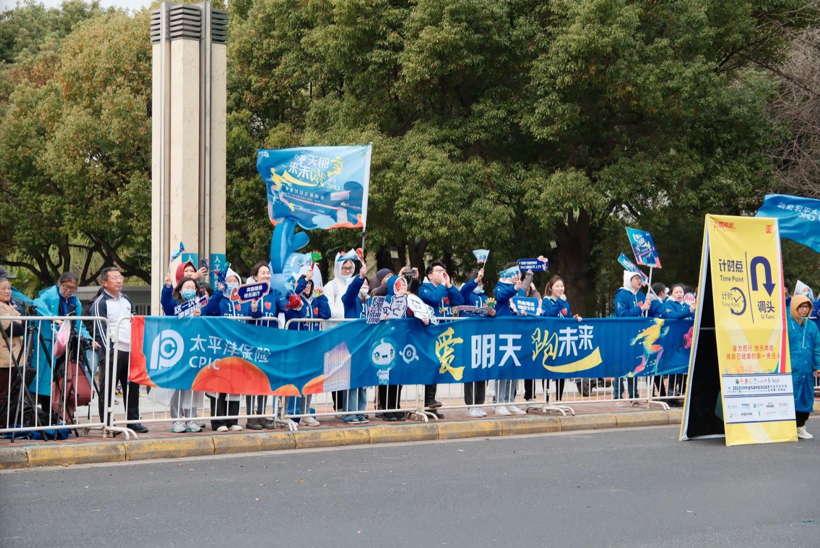 中国太保助威团成员摇旗呐喊，与路过的金马选手们一起“为爱奔跑”。