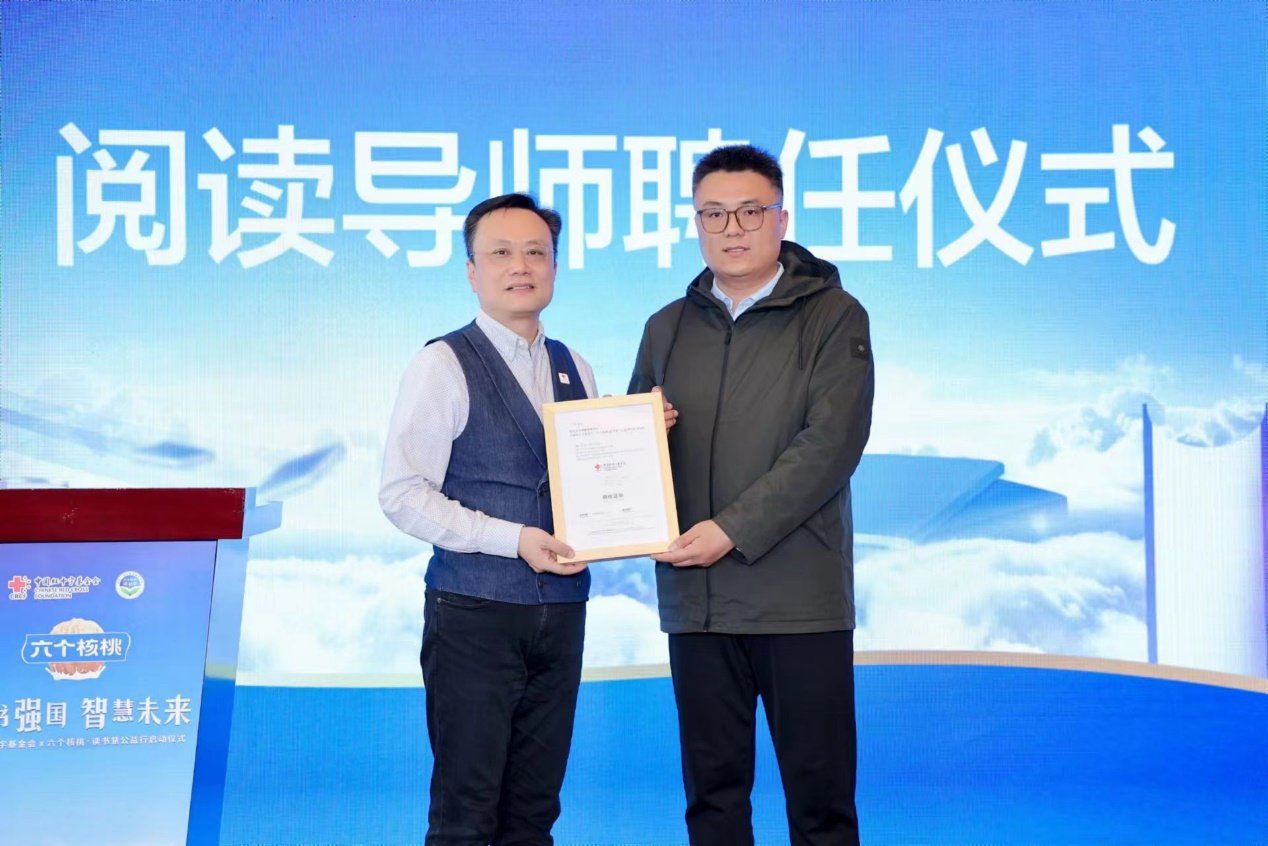 （中国红十字基金会副秘书长郭阳向山东曲阜陵城镇杏坛小学卢宁老师颁发此次活动“阅读导师”聘书）