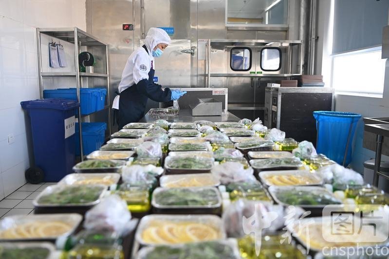 图为工作人员对餐食进行封膜包装。 中新社记者 九美旦增 摄