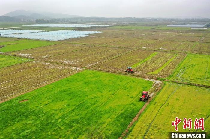 图为航拍江西上高县的广袤田野，几台农机正在翻耕土地，一派繁忙景象。　陈旗海 摄