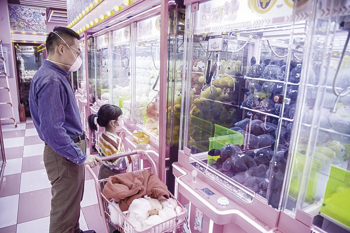 商场里，孩子在开心地玩着“抓娃娃”。