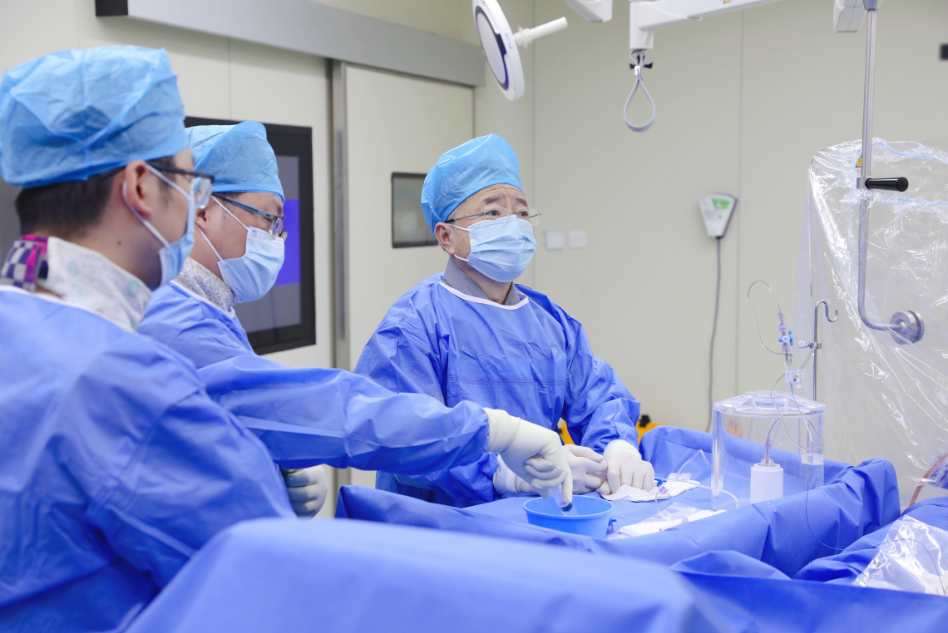 图为：滕皋军院士（右一）带领团队正在施行全球首例国产钇90炭微球介入手术。王倩摄
