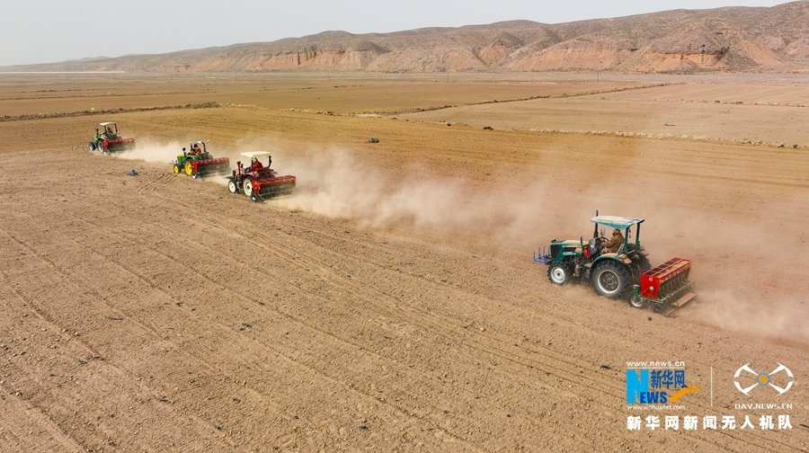 甘肃省张掖市民乐县顺化镇张宋村小麦种植基地，大型机械正在播种小麦。新华网发 （陈思宏 摄）