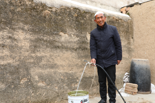 在甘肃省临夏回族自治州东乡族自治县大树乡米家村，村民在院中接自来水。新华每日电讯记者 多蕾 摄