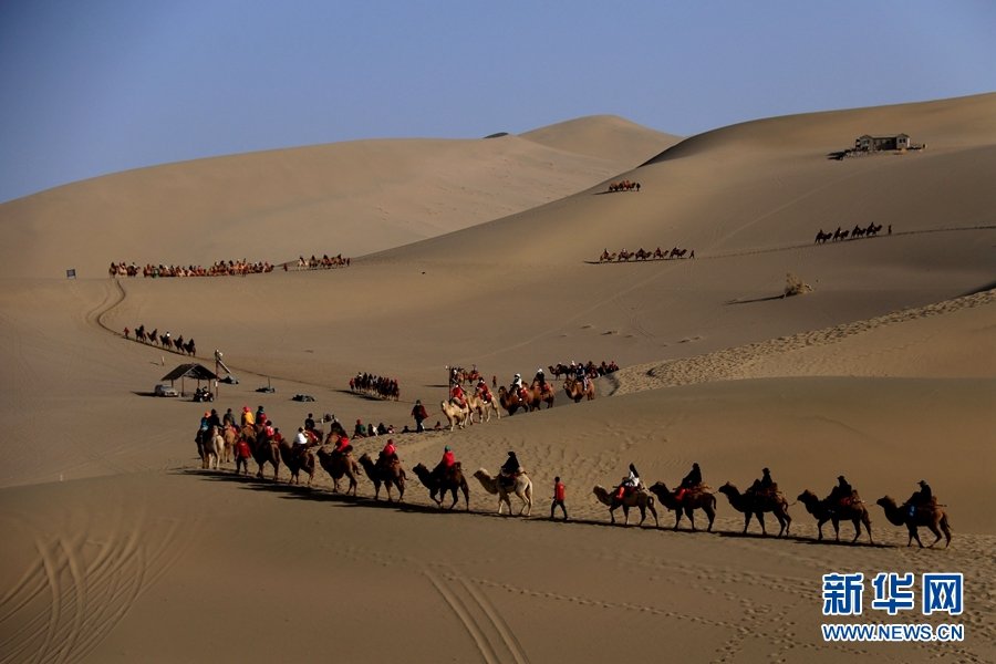 3月25日，游客在甘肃省敦煌市鸣沙山月牙泉景区游览。新华网发 (张晓亮 摄)