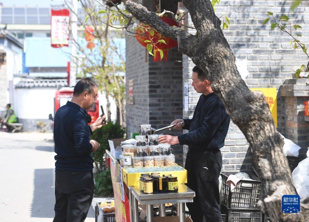 3月29日，游客在宁陵县万亩梨园景区购买酥梨深加工产品。新华社记者 张浩然 摄