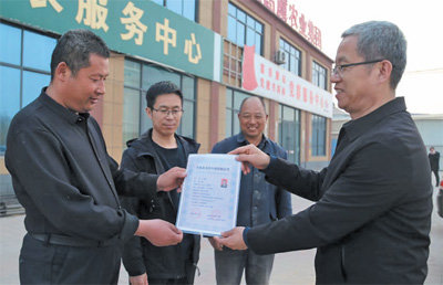 山东省平原县乡村振兴服务中心工作人员为农民农艺师王笃春（左一）颁发证书 辛凯 摄