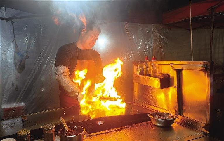 榆中县夜市烧烤老板正在烤制食物 杨贵智 摄