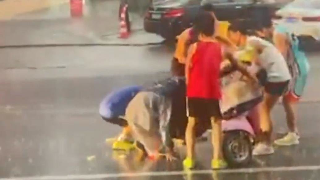 学生一次次冲进暴雨中，扶起多名摔倒的骑手