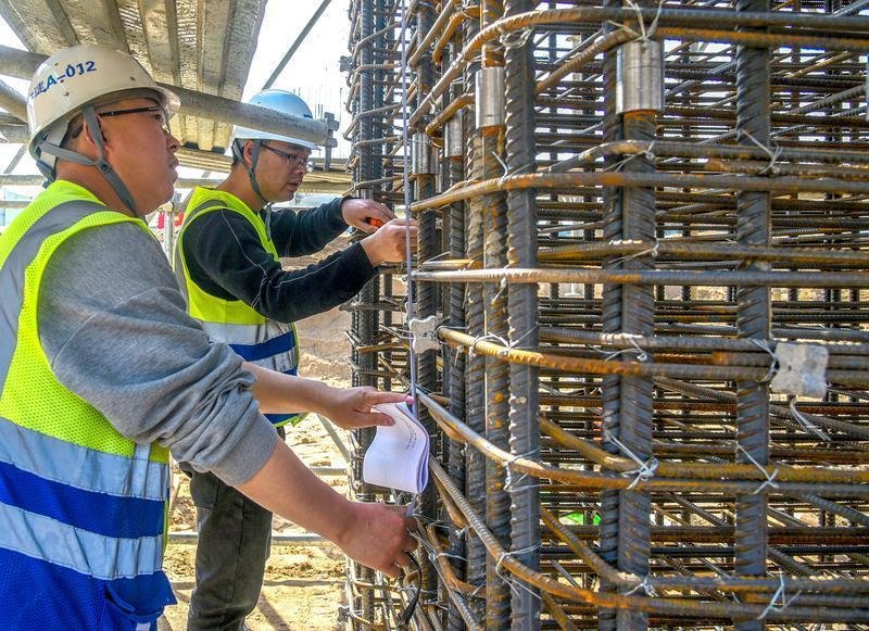 3月27日,施工管理人员在欧亚大道上跨货运北环线高架工程现场进行墩柱