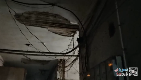一栋老楼屋内，电线老化、墙面脱落