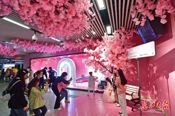 4月1日，江汉路地铁站C出入口的站厅樱花角，众多市民游客拍照打卡。记者李永刚 摄