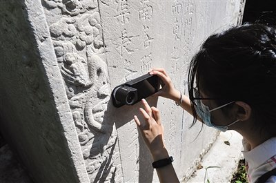 学生用专业设备观察石碑表面的微观形貌。