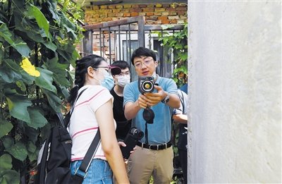 北京市考古研究院科技保护研究室主任张涛（右一）给学生示范仪器使用方法。