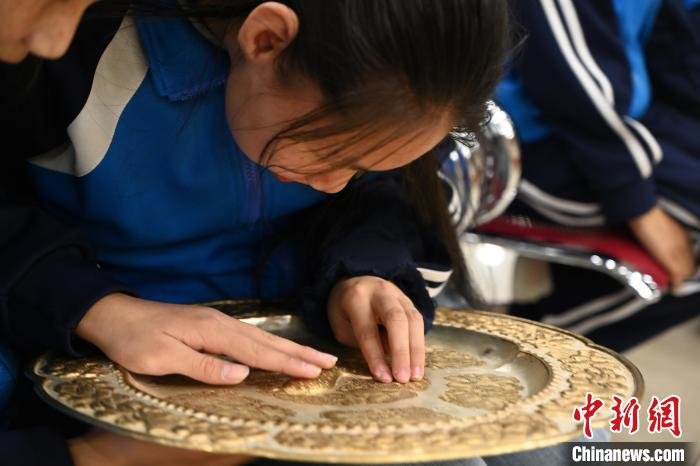 内蒙古呼和浩特市,视障学生触摸感受文物复制品。 刘文华 摄