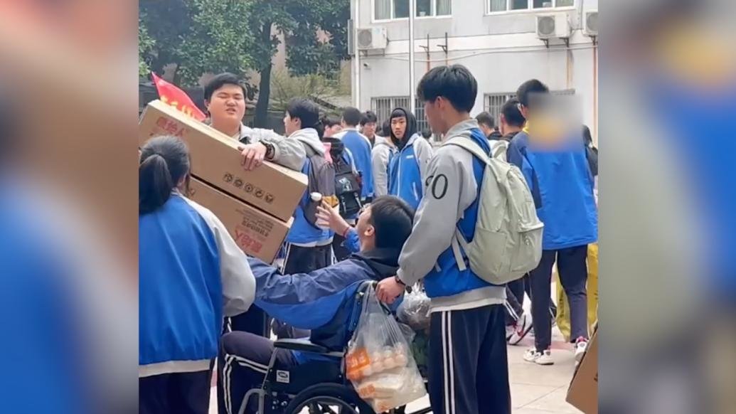 高中男生腿受伤同学推着他春游