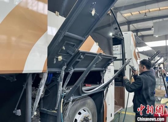 江西凯马百路佳客车有限公司客车总装部，生产一线的员工正加紧车辆组装。　卢梦梦 摄