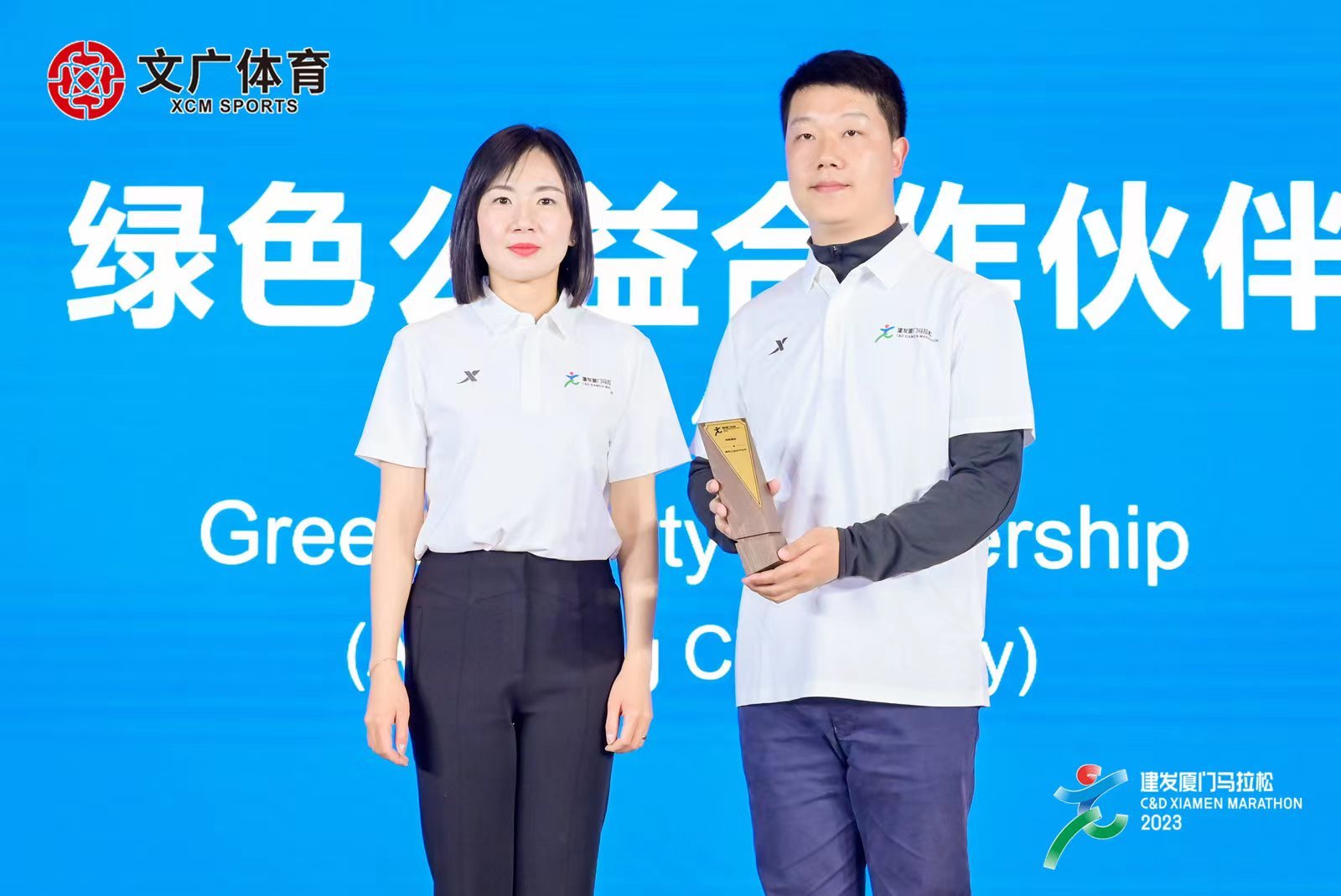 图注:厦门文广体育有限公司总经理、厦门马拉松公益基金会副理事长花云(左)向蚂蚁集团可持续发展部总监王小颖(右)授予“2023建发厦门马拉松赛绿色公益合作伙伴”牌匾