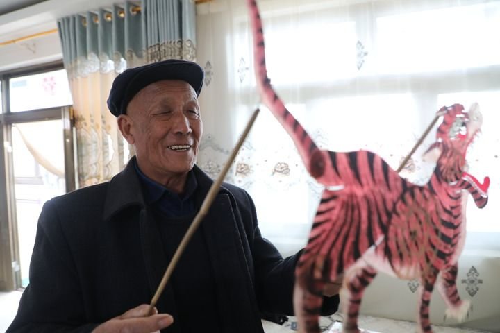 3月15日，甘肃省庆阳市环县道情皮影艺人敬廷孝在展示他收藏的皮影。