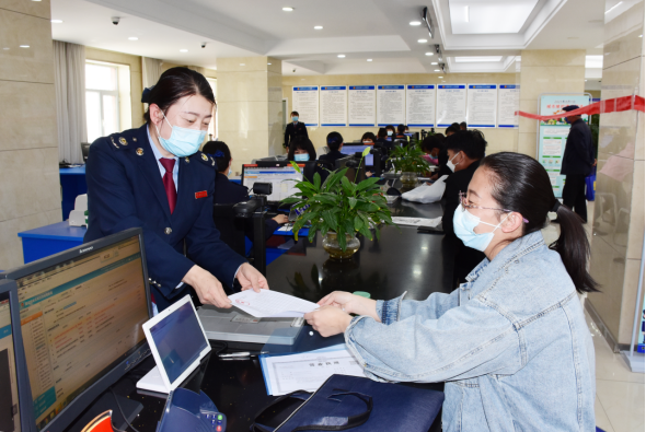 办税服务厅工作人员为纳税人办理业务