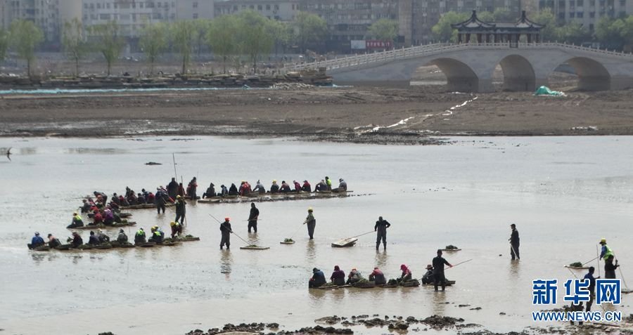 4月9日，工人在河南省开封市包公湖湖底“种草”。