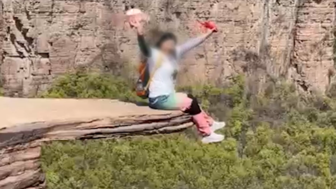 悬崖“试胆石”现裂缝仍有游客坐边缘打卡，镇政府：已经砸了