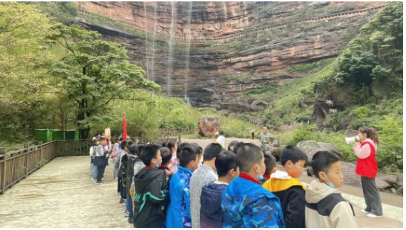 讲解员给学生介绍四面山景观