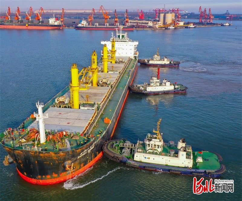一艘轮船在拖轮协助下向河北港口集团唐山港京唐港区码头靠泊。