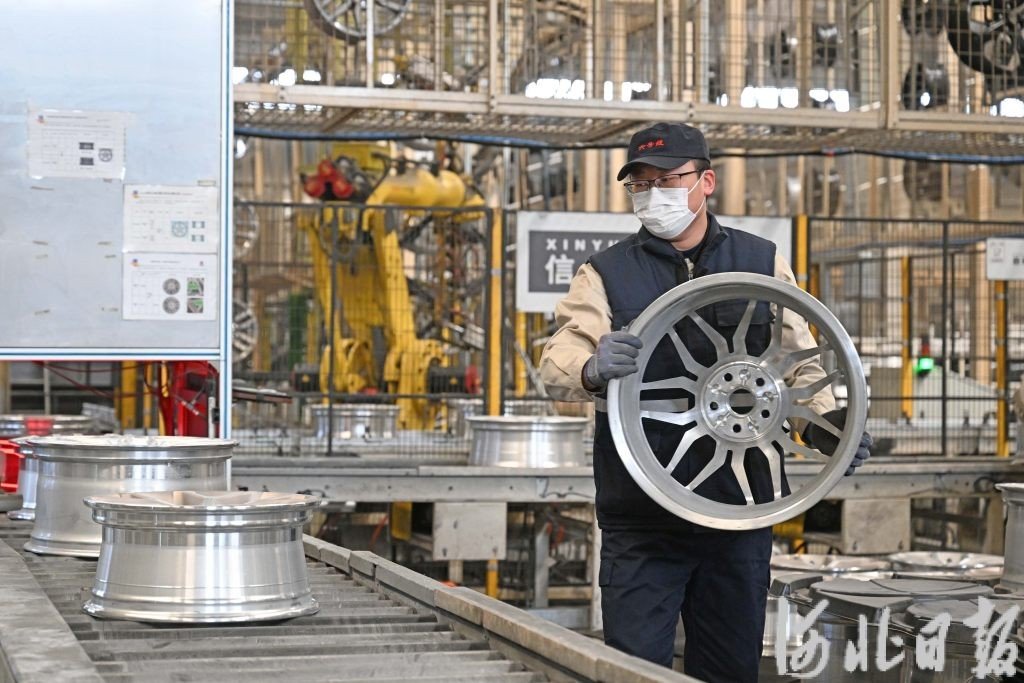 中信戴卡秦皇岛铝车轮工厂员工在智能化生产线上工作。