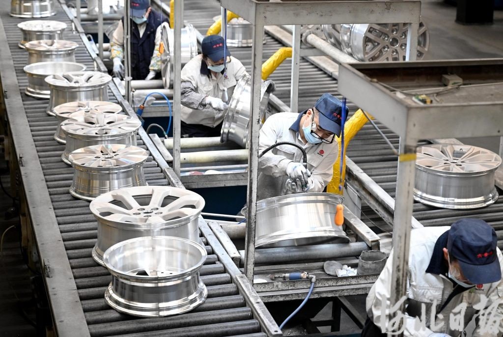中信戴卡秦皇岛铝车轮工厂员工在智能化生产线上工作。